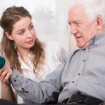 Physical therapist with senior using dumbbells